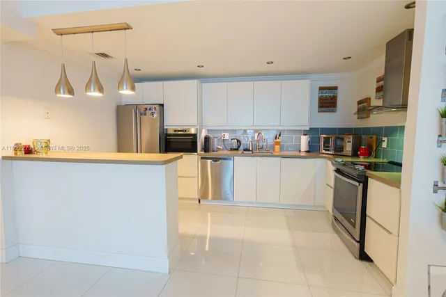 a kitchen with stainless steel appliances a refrigerator sink and cabinets