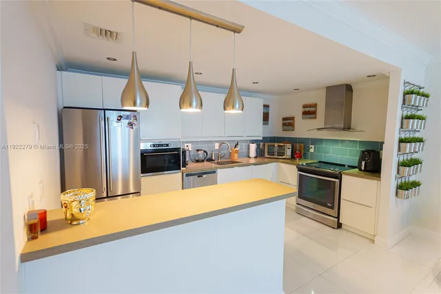 a kitchen with stainless steel appliances granite countertop a sink and a refrigerator
