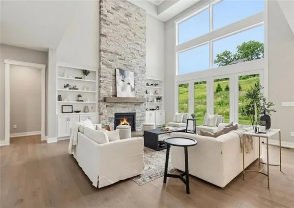a living room with furniture a fireplace and a large window