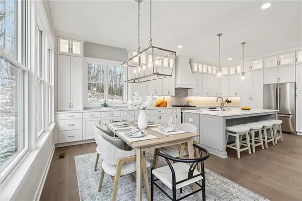 a kitchen with a dining table chairs and large windows