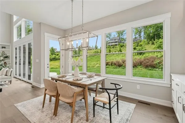a dining room with furniture a chandelier and wooden floor