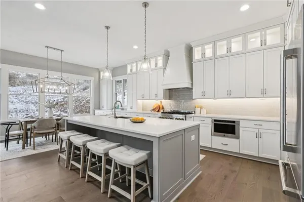 a kitchen with a stove and chairs