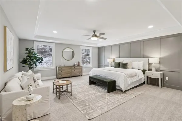 a spacious bedroom with a bed a couch and a potted plant