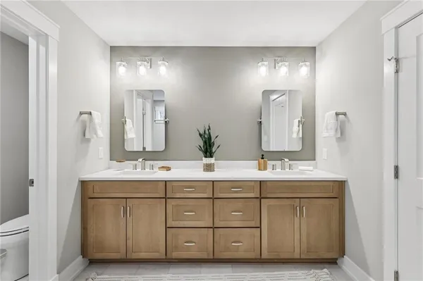a bathroom with a double vanity sink mirror and toilet