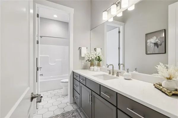 a bathroom with a double vanity sink mirror and bathtub
