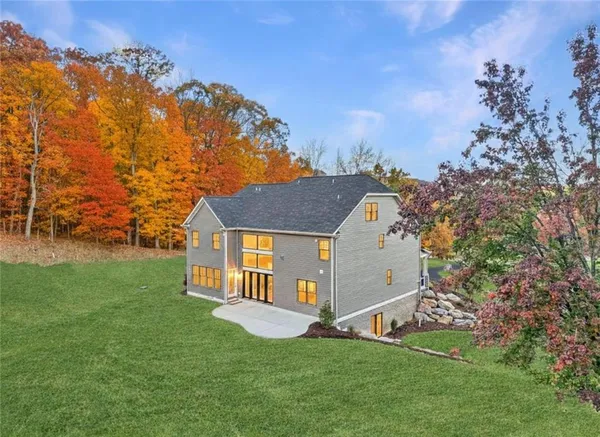 a front view of a house with a yard and trees
