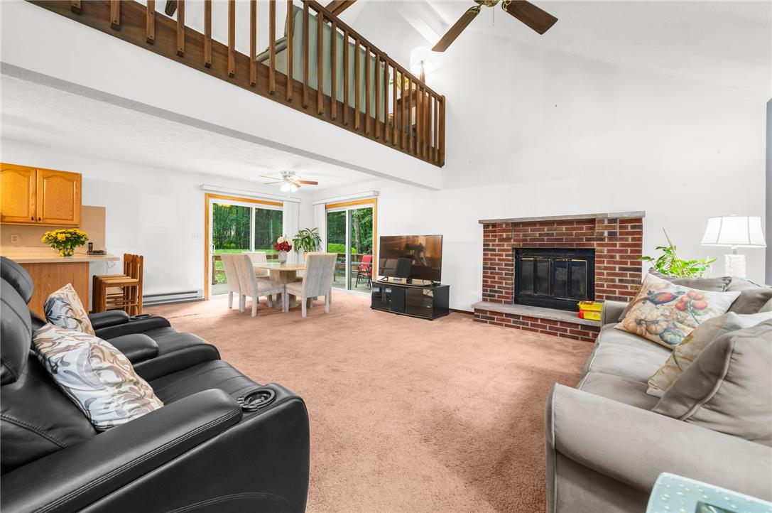 222 Powder Horn Road Henryville, PA 18332 - Photo 6 of 25 A striking brick fireplace grounds this open-concept living space with soaring vaulted ceilings.