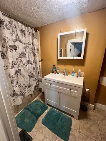a bathroom with a sink mirror and a bathtub