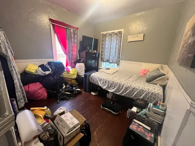 a bedroom with a bed next to a window