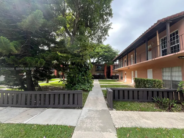 a view of street with small yard and wooden fence