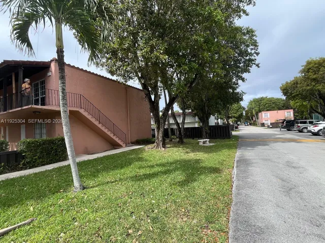 a car parked in front of a house with a yard