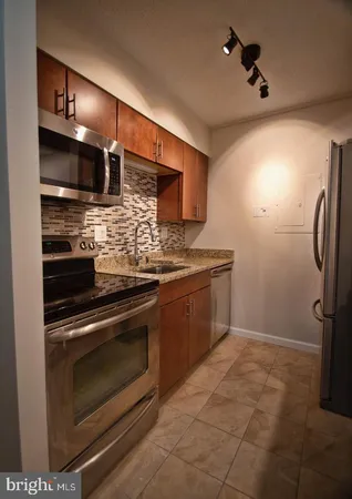 a kitchen with stainless steel appliances kitchen island granite countertop a stove and a refrigerator