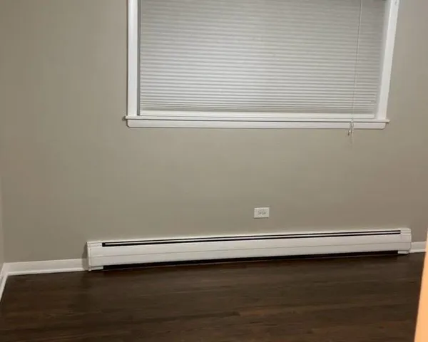 a view of a small space with wooden floor and a window