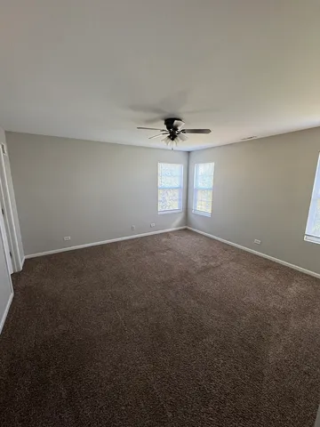 a view of a room with a ceiling fan and a window