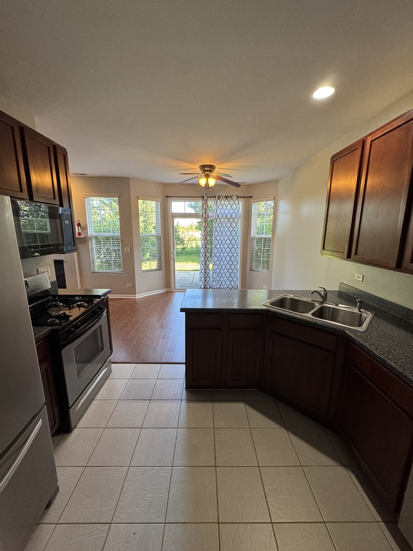 1401 Millbrook Drive Algonquin, IL 60102 - Photo 3 of 14 a kitchen with granite countertop a stove a sink and a refrigerator
