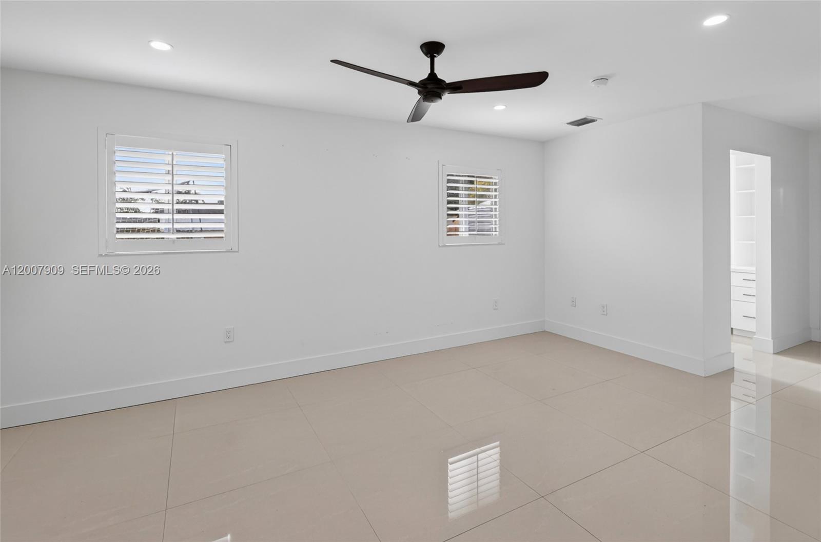 4865 Southwest 94th Avenue Miami, FL 33165 - Photo 17 of 32 an empty room with a window and a ceiling fan