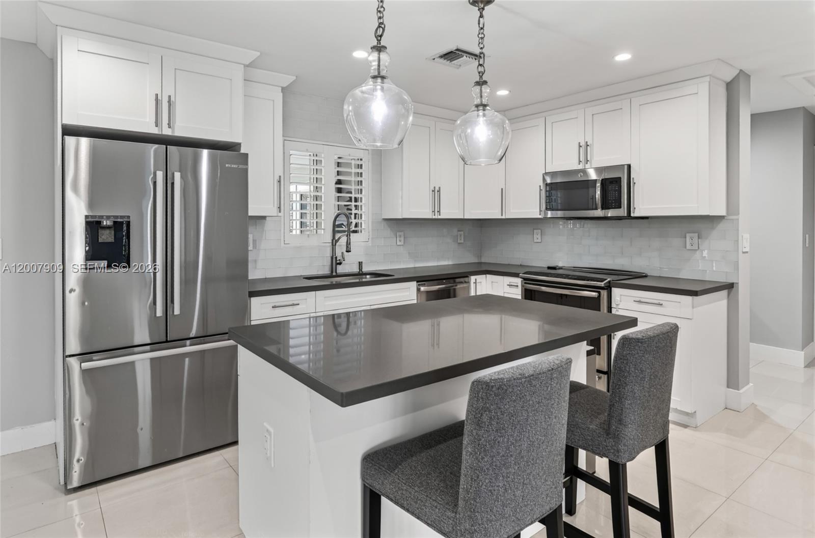 4865 Southwest 94th Avenue Miami, FL 33165 - Photo 7 of 32 a kitchen with stainless steel appliances granite countertop a refrigerator a sink a stove a microwave and island