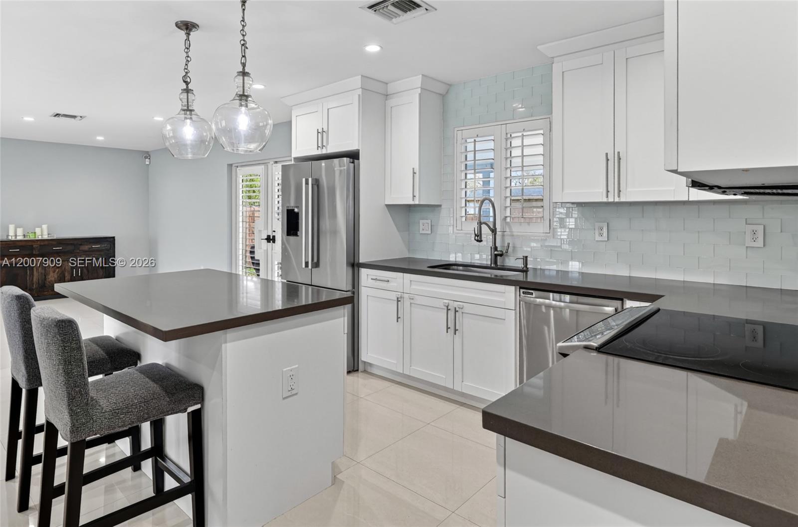 4865 Southwest 94th Avenue Miami, FL 33165 - Photo 8 of 32 a kitchen that has a lot of cabinets in it and wooden floors