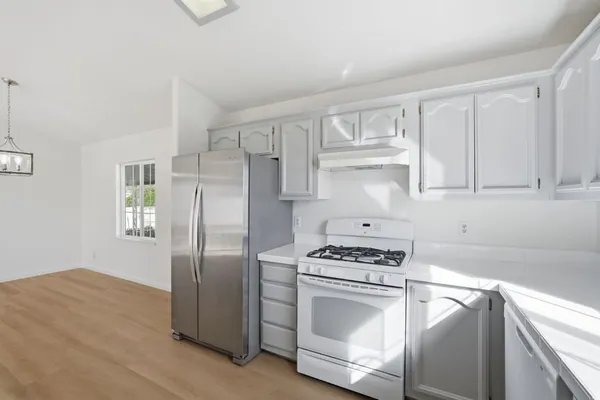 a kitchen with white cabinets and stainless steel appliances