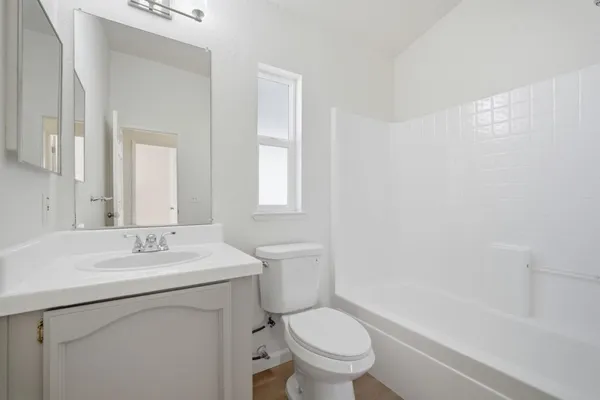 a bathroom with a sink toilet vanity and tub