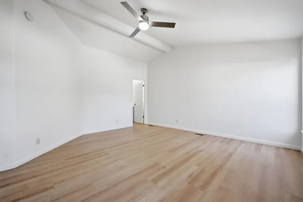 a view of an empty room with wooden floor