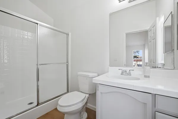 a bathroom with a sink toilet vanity and shower