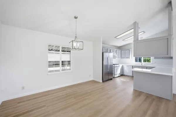 a kitchen with stainless steel appliances granite countertop a sink a window and wooden floor