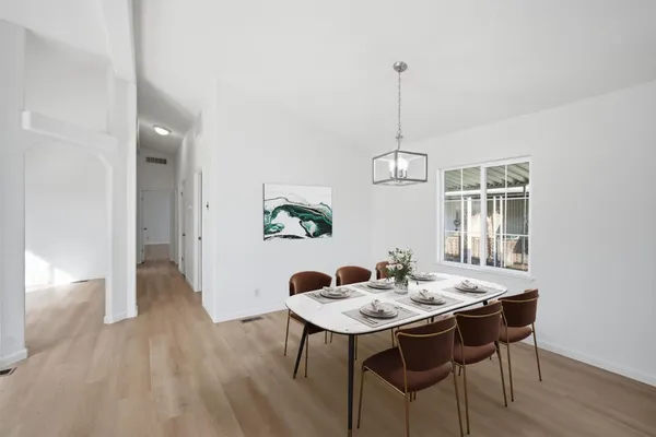 a view of a dining room with a table and chairs