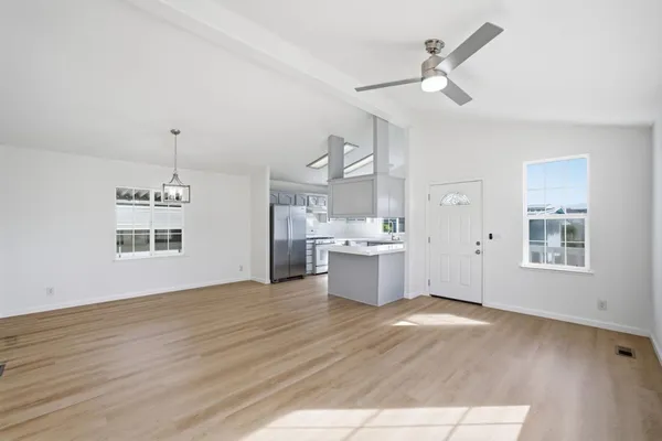 a view of a room with wooden floor and white walls