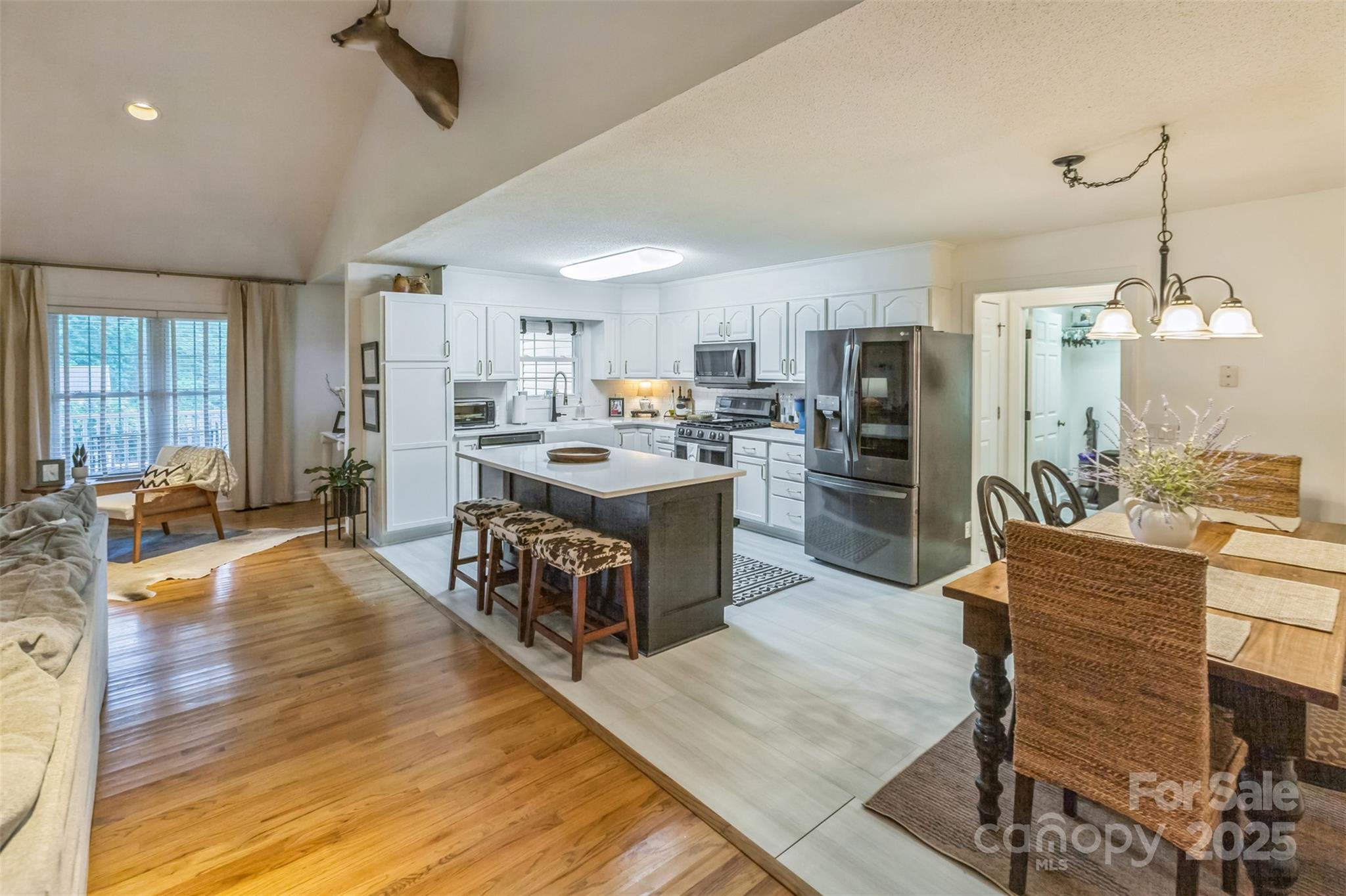 150 Marys Lane Rutherfordton, NC 28139 - Photo 11 of 35 a open kitchen with stainless steel appliances granite countertop a refrigerator a stove top oven a sink dishwasher and couches with wooden floor