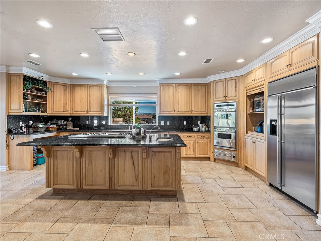 7139 Foley Road Oak Hills, CA 92344 - Photo 19 of 72 a kitchen with stainless steel appliances granite countertop a refrigerator and a sink