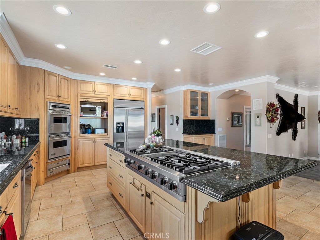 7139 Foley Road Oak Hills, CA 92344 - Photo 22 of 72 a kitchen with stainless steel appliances granite countertop a stove and a refrigerator