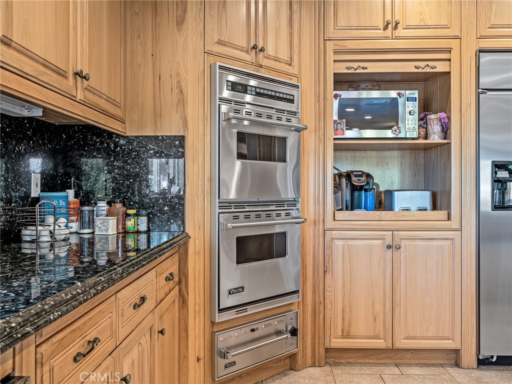 7139 Foley Road Oak Hills, CA 92344 - Photo 23 of 72 a kitchen with granite countertop a refrigerator and cabinets