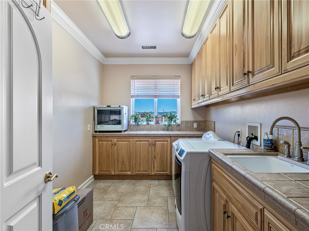 7139 Foley Road Oak Hills, CA 92344 - Photo 27 of 72 a kitchen with granite countertop a sink a stove a refrigerator and cabinets