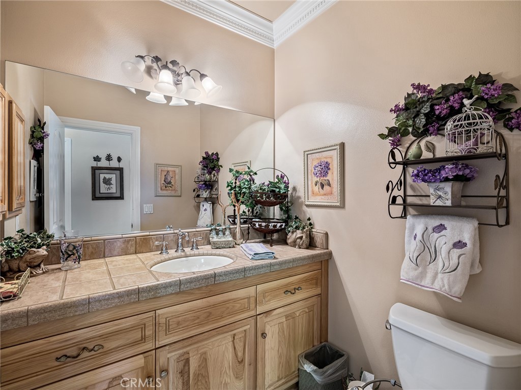 7139 Foley Road Oak Hills, CA 92344 - Photo 28 of 72 a bathroom with a sink a mirror and a toilet