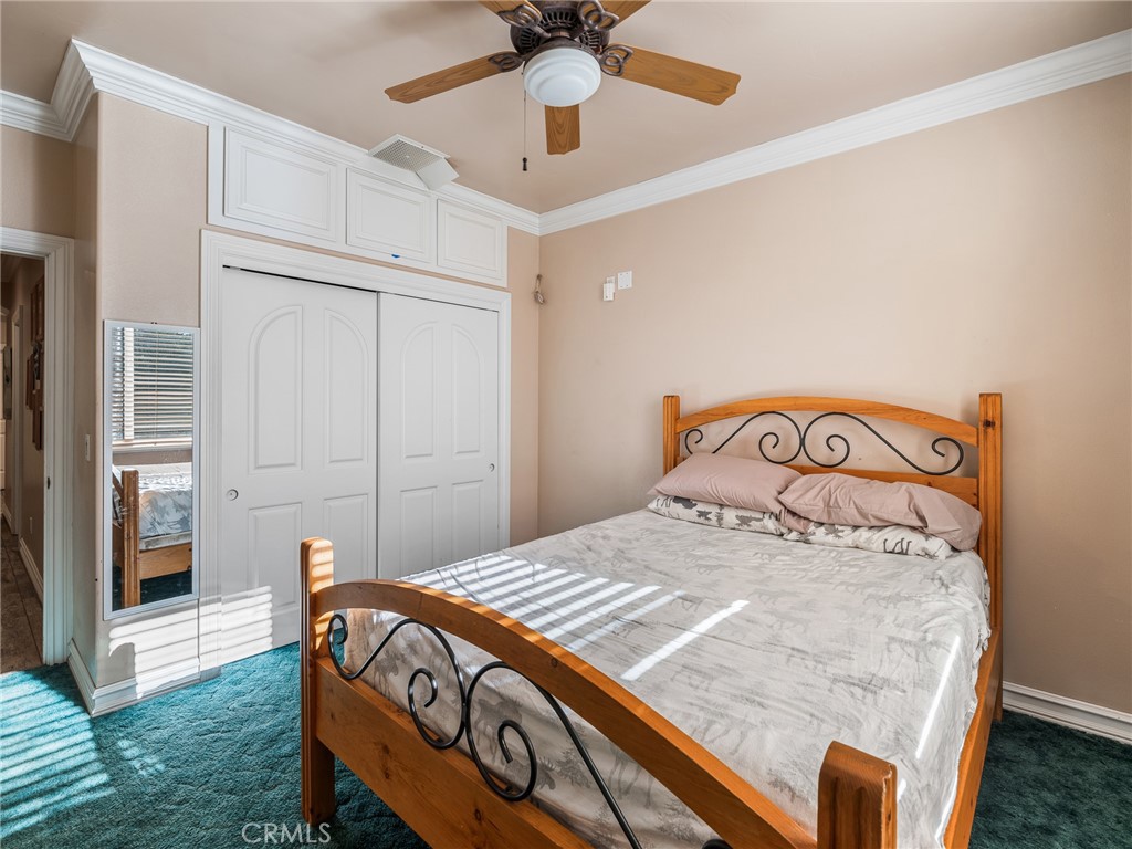 7139 Foley Road Oak Hills, CA 92344 - Photo 33 of 72 a bedroom with a bed and a chandelier