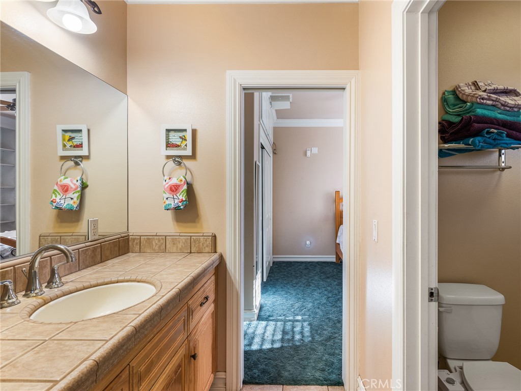 7139 Foley Road Oak Hills, CA 92344 - Photo 36 of 72 a en suite bathroom with a granite countertop sink and a mirror