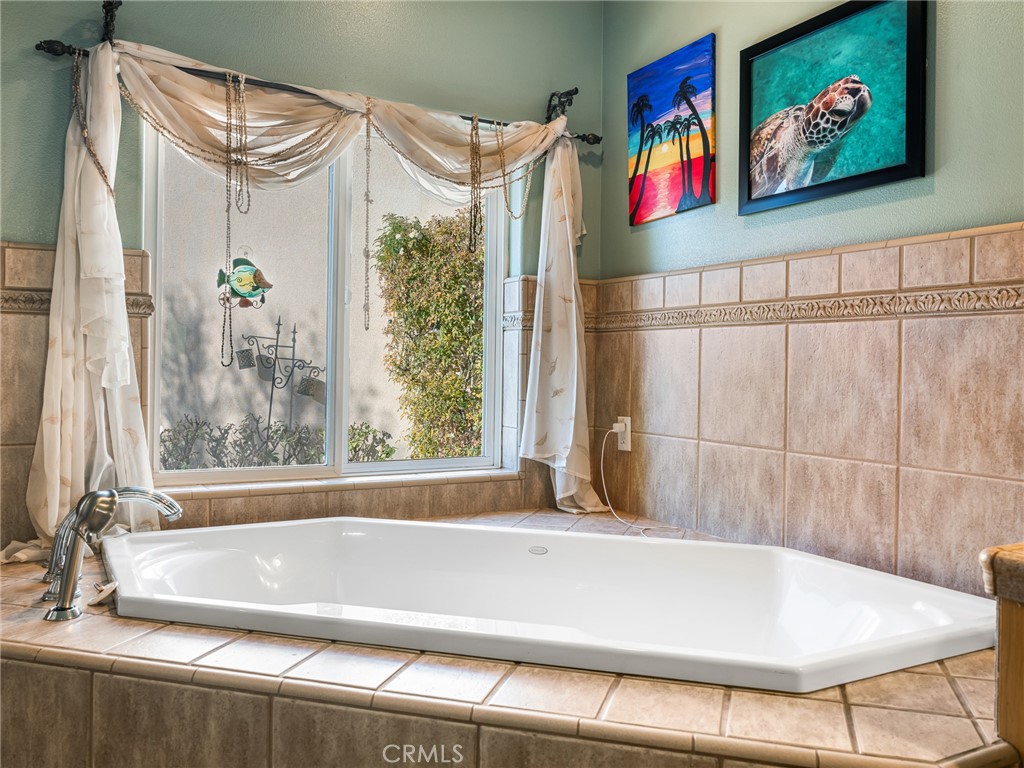 7139 Foley Road Oak Hills, CA 92344 - Photo 47 of 72 a bathroom with a bathtub and a shower