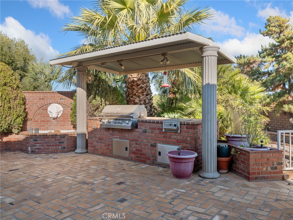 7139 Foley Road Oak Hills, CA 92344 - Photo 57 of 72 a view of a backyard with table and chairs potted plants