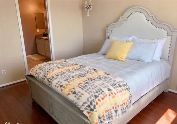 a bedroom with a bed and wooden floor