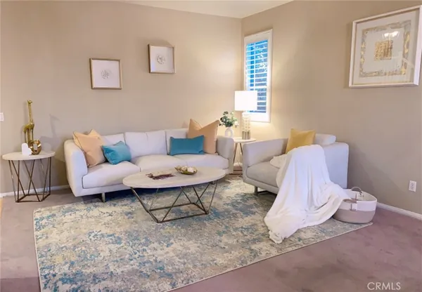 a living room with furniture a rug and a window