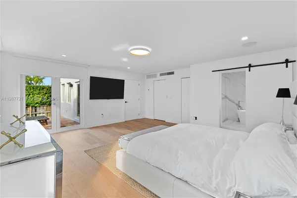 a bedroom with a bed window and a flat screen tv