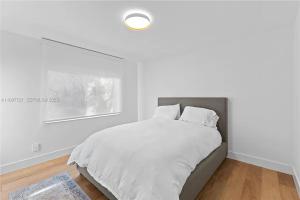 a large bed sitting in a bedroom next to a window