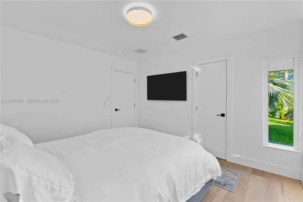 a bedroom with a bed and a flat screen tv