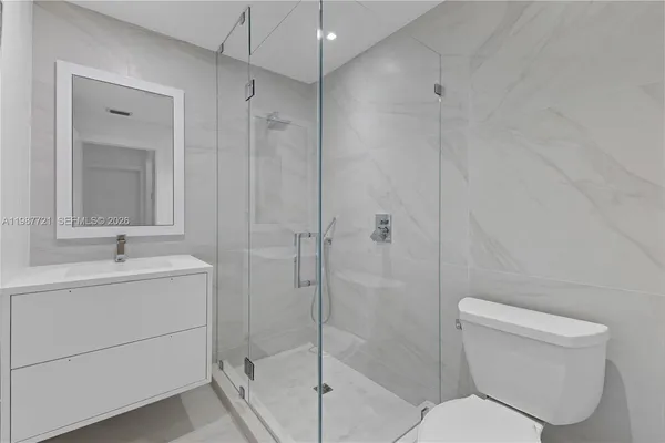 a bathroom with a toilet sink vanity and tub