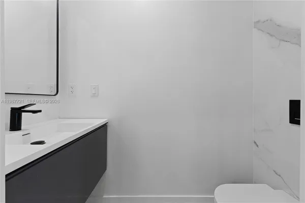 a bathroom with a sink a toilet and mirror