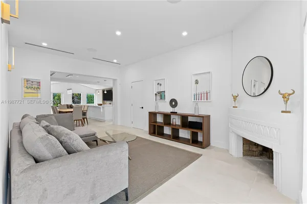 a living room with furniture a fireplace and a chandelier
