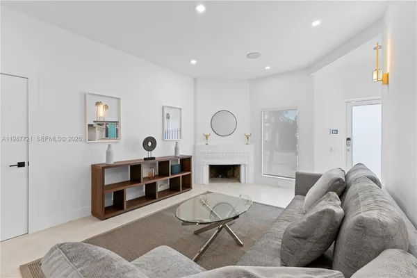 a living room with furniture a rug and white walls