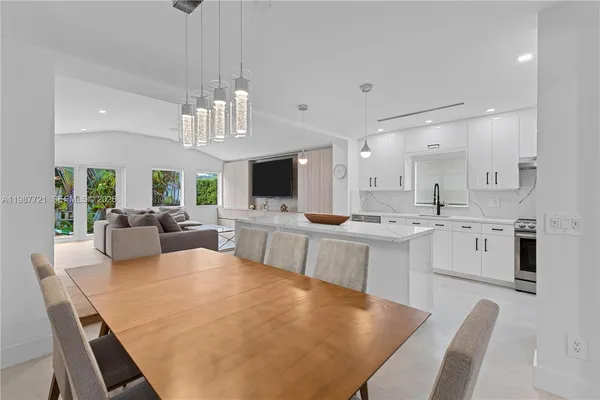 a large white kitchen with cabinets a sink and stainless steel appliances