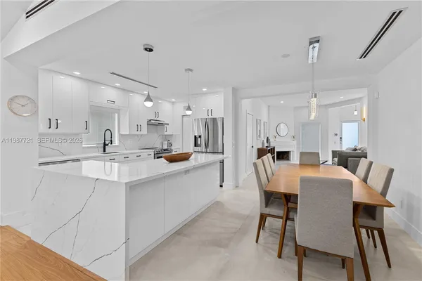 a large kitchen with a table and chairs